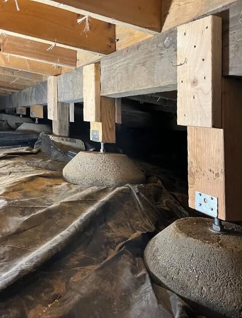 Steel adjustable support columns and vapor barrier installed in crawl space to correct sagging floors